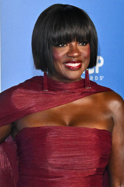 Viola Davis smiling in a burgundy strapless dress and cape